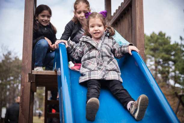 istock Happy girls having fun on a park slide 1217412025