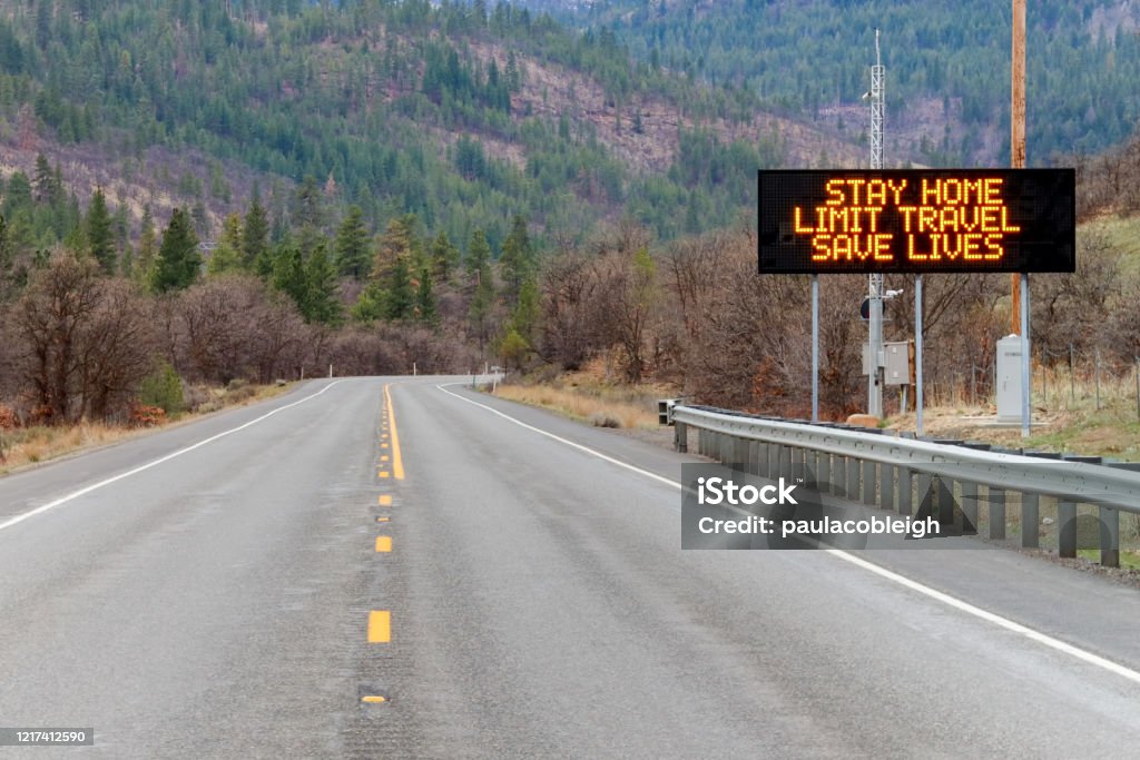 Electronic sign along U.S. Highway 97 notifying people to stay home and save lives by reducing the risk of being infected due to COVID-19 Highway Stock Photo