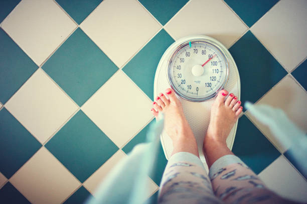 woman stands in the bathroom on the scales in the morning - weight scale dieting weight loss imagens e fotografias de stock