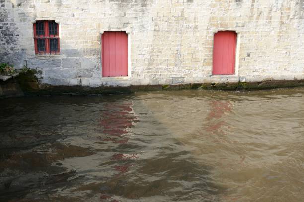 Wooden red doors and window beside canal in the old town of Brugge, Belgium.