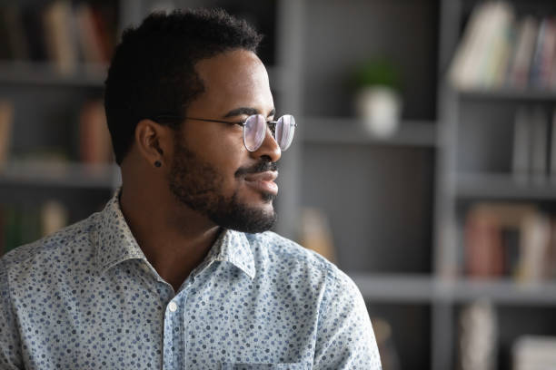 Thoughtful african American man look in distance visualizing