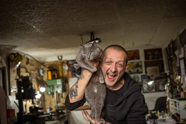 Smiling man with his cat in a tattoo studio