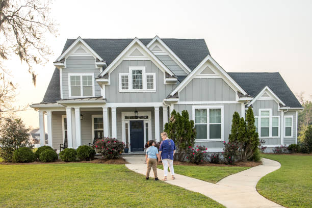 istock From behind, a single mom and her son standing in front of a new construction house looking at it 1217414318