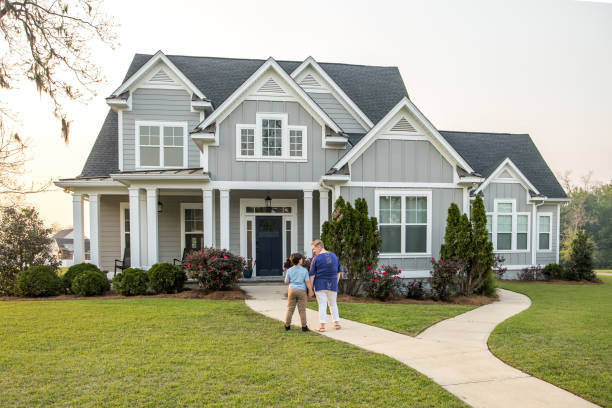 istock From behind, a single mom and her son standing in front of a new construction house looking at it 1217414332