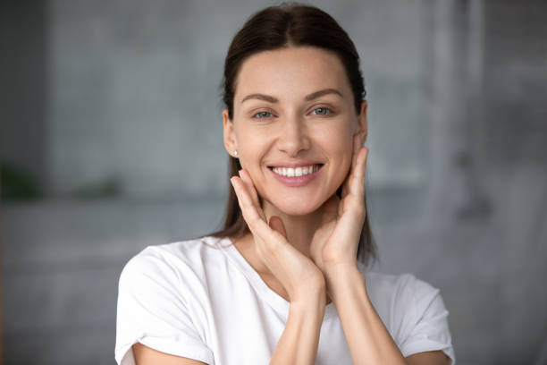 istock Smiling woman touching cheeks, satisfied with good skin condition. 1217416355