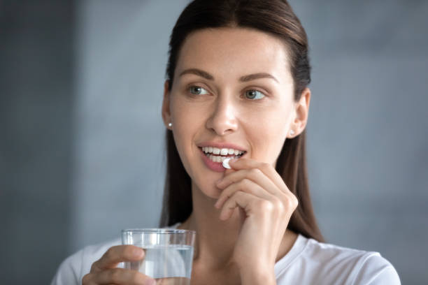 istock Pretty young lady takes daily omega vitamins. 1217416392