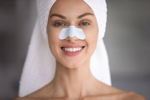 istock Happy lady with cleansing strip on nose looking at camera. 1217416437