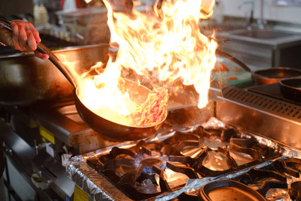 istock cooking with flame in a frying pan on a kitchen stove 1217420253