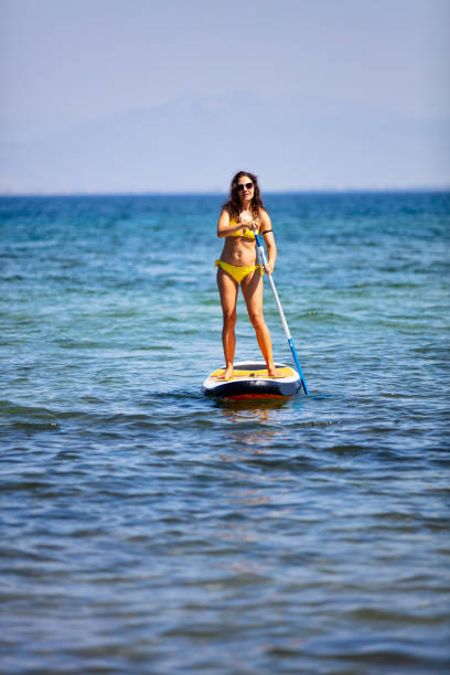 istock Attractive brunette on a stand up paddle board 1217420609
