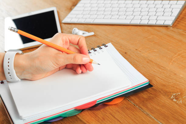 istock Female hands working on wooden work place with modern gadgets 1217420792