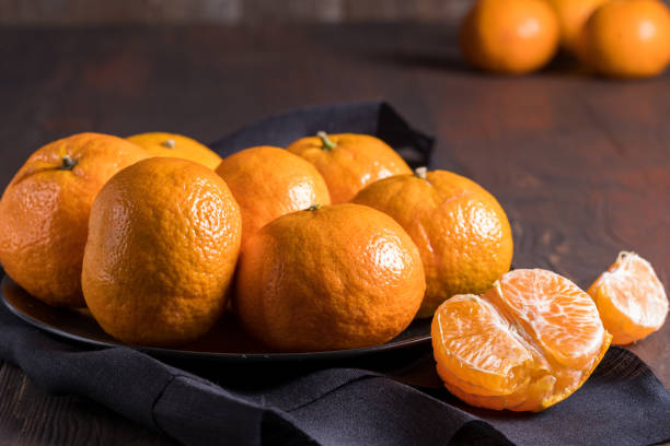 istock Fresh mandarin oranges fruit or tangerines on wooden background. 1217420820