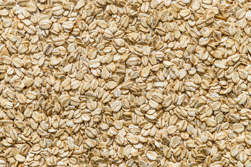 Top view of an uncooked oat flakes background.