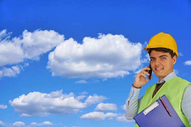 istock Young engineer with helmet  and clipboard, speaking on mobile phone 1217424050