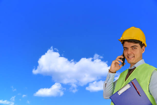 istock Young engineer with helmet  and clipboard, speaking on mobile phone 1217424466