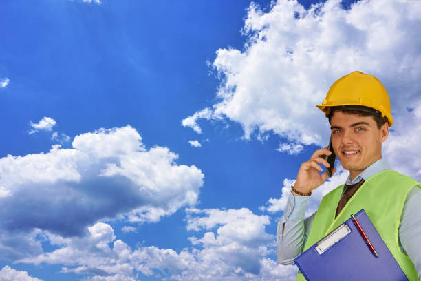 istock Young engineer with helmet  and clipboard, speaking on mobile phone 1217424891