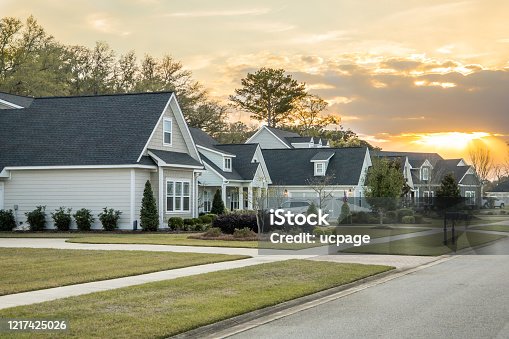 istock A Street view of a new construction neighborhood with larger landscaped homes and houses with yards and sidewalks taken near sunset 1217425026