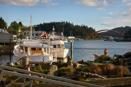The La Conner waterfront in the sun on Swinomish Channel. The Rainbow Bridge in the background.