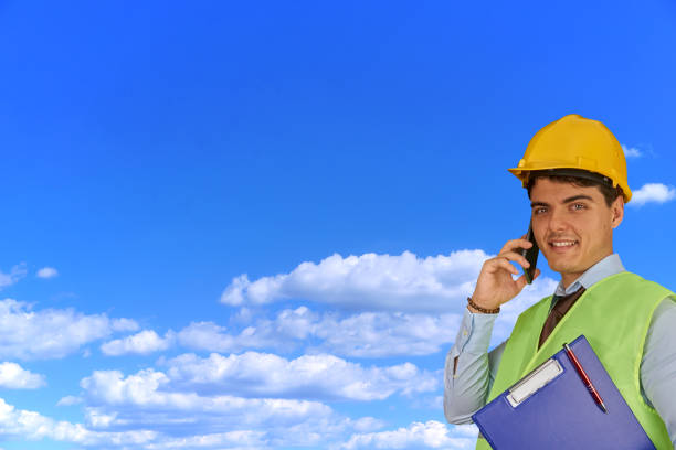 istock Young engineer with helmet  and clipboard, speaking on mobile phone 1217426262