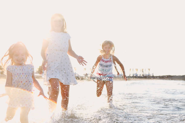 istock Happy kids running in sea water 1217426462