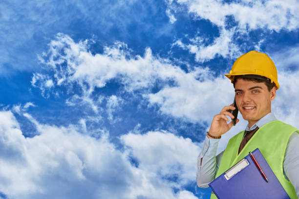 istock Young engineer with helmet  and clipboard, speaking on mobile phone 1217427348
