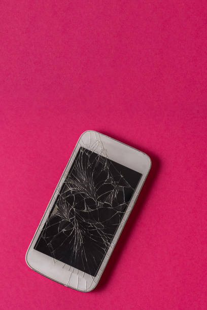 istock Broken mobile phone with cracked display on blue background, flat lay. 1217430981