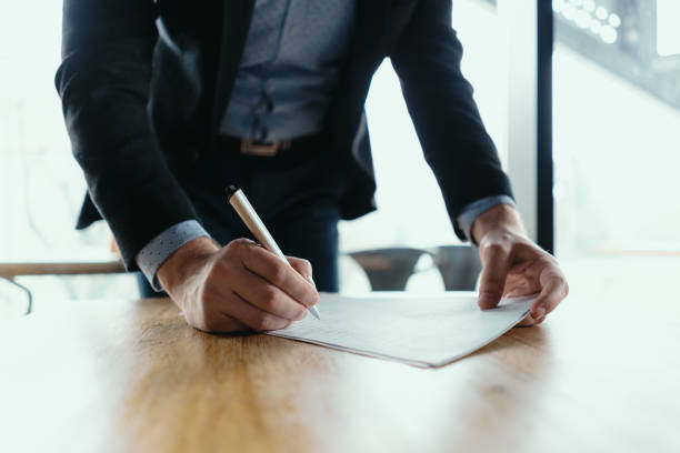 istock Successful business man signing documents in a modern office 1217431326