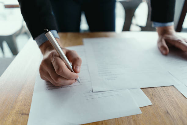 istock Successful business man signing documents in a modern office 1217431340