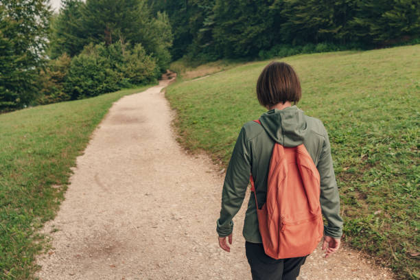 istock Female hiker walking on footpath outdoors 1217434754