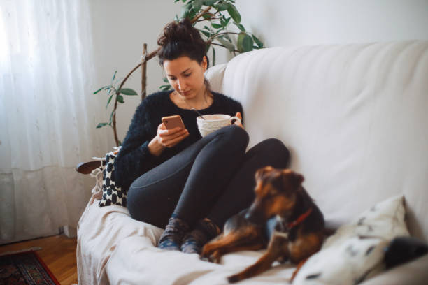 istock Woman relaxing on the couch with her dog 1217434998