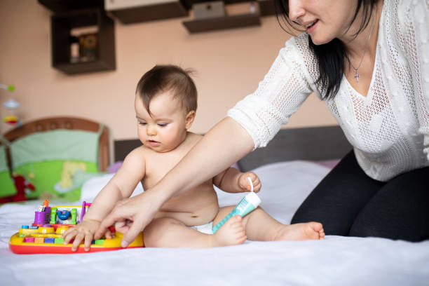 istock Baby and mom playing on the bed 1217438626