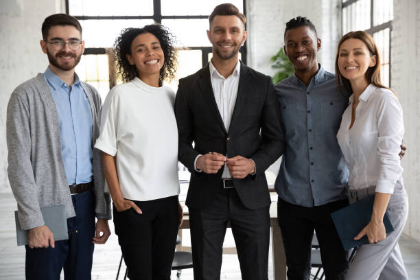 istock Standing in row smiling diverse team looking at camera. 1217439335