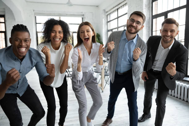 istock Overjoyed standing in row smiling diverse team looking at camera. 1217439338