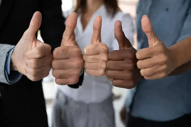 Photo of Diverse business team people hands showing thumbs up.