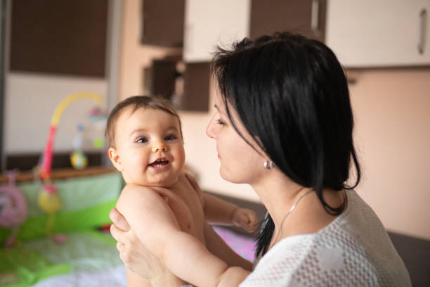 istock Baby and mom playing on the bed 1217440072