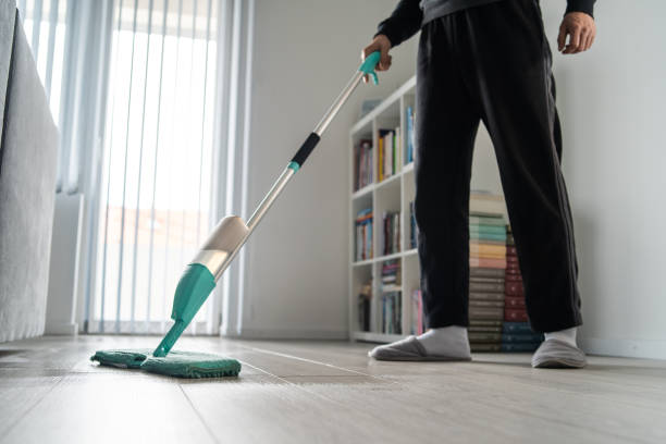 istock Side view male using mop unknown caucasian adult man doing housework at home husband mopping wooden parquet or laminate floor in the room in day keeping hygiene cleaning disinfection living room 1217442025