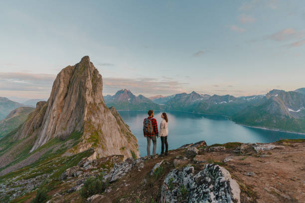 Woman and man standing with view on Senja island young Caucasian heterosexual couple standing with view on Senja island, Norway senja island photos stock pictures, royalty-free photos & images