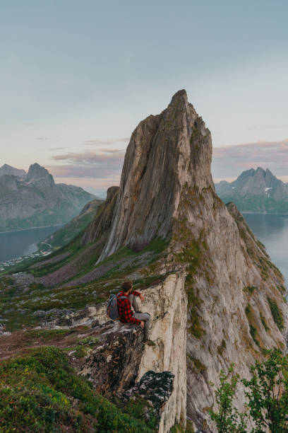 istock Man sitting and looking at Segla   mountain on Senja island 1217444327