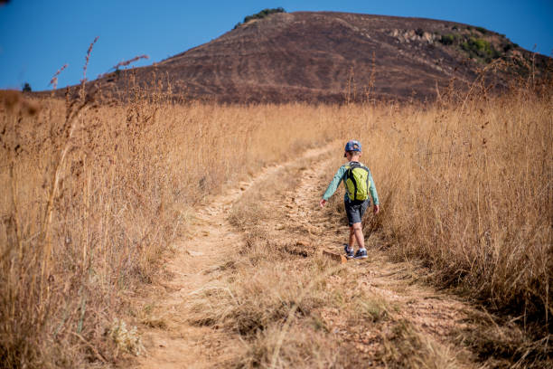 istock A Young boy walks up a path for a hike. 1217449747
