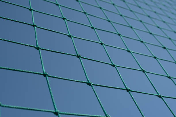istock Green tennis or volleyball net against blue sky. Grid pattern abstract background. 1217450614