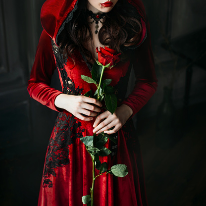 Retrato Primer Plano Silueta Gótica Mística Vampiro Mujer Vestido Largo De Lujo Capucha Collar Vintage La Reina Medieval Sostiene La Rosa Roja En Las Manos Pelo Ondulado Negro Maquillaje Festivo De Halloween Retrato Primer Plano Silueta Gótica Mística Vampiro Mujer Vestido Largo De Lujo Capucha Collar Vintage La Reina Medieval Sostiene La Rosa Roja En Las Manos Pelo Ondulado Negro Maquillaje Festivo De Halloween