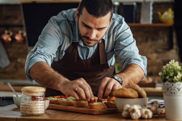 istock Young chef preparing bruschetta in the kitchen. 1217452107
