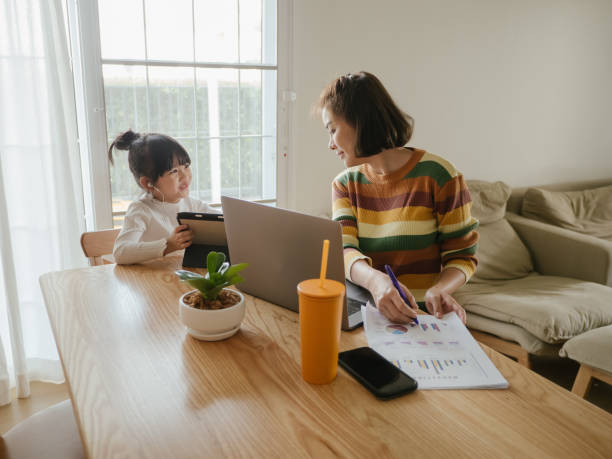 istock Young mother working from home with daughter on table. 1217452167