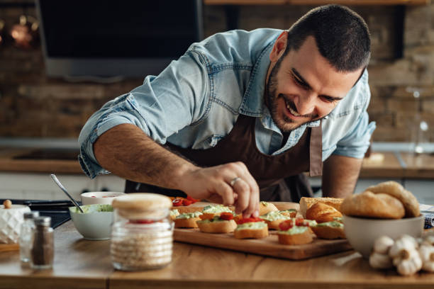 istock Happy man enjoying in preparing a healthy appetizer in the kitchen. 1217452218