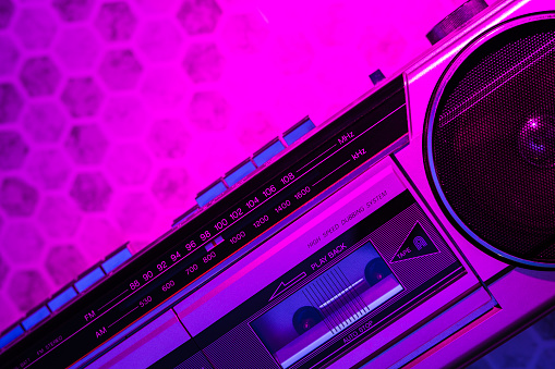 A vintage boombox lit with a 80's / 90's neon light