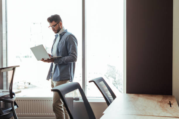istock IT worker with laptop near windows in coworking space 1217453638