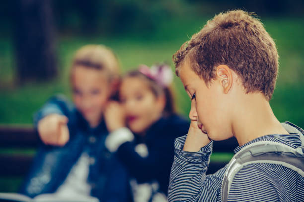 istock Sad boy feeling left out, teased and bullied by his classmates. 1217454689