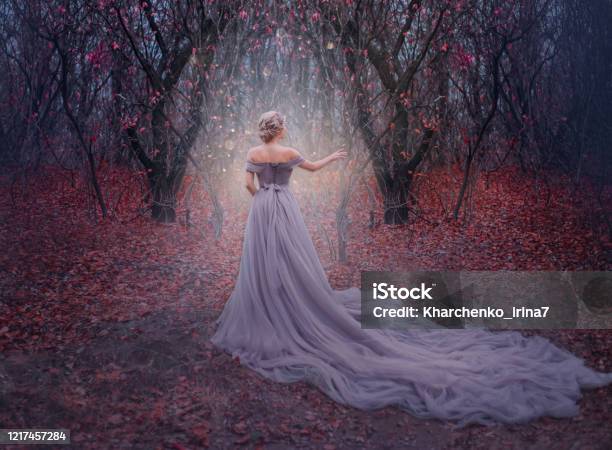Art Photo Young Beauty Woman Queen Autumn Purple Mystic Tree Fantasy Entrance World Magic Divine Glowing In Dark Deep Forest Lady Princess In Elegant Vintage Dress Long Train Back Medieval Clothes Stock Photo - Download Image Now
