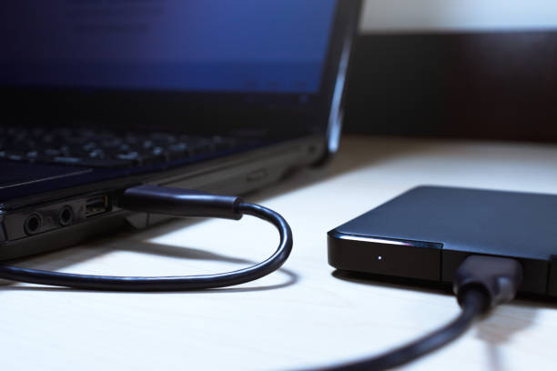 External Disk Connected to Laptop External disk connected to laptop on white table. external hard disk drive stock pictures, royalty-free photos & images