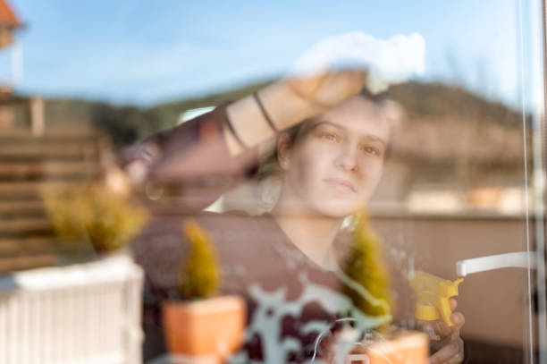 istock Young girl cleaning window at home 1217463424