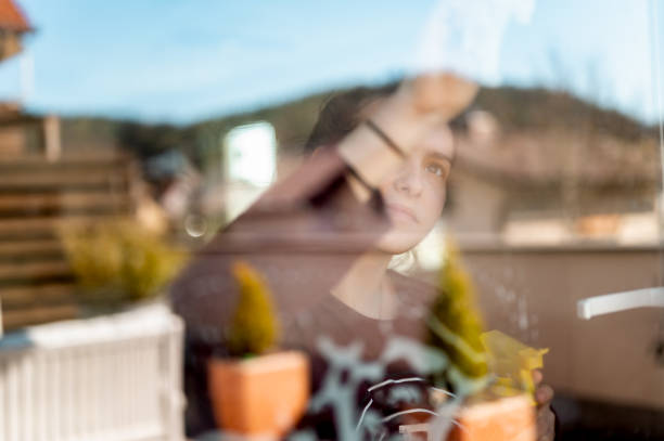 istock Young girl cleaning window at home 1217463464
